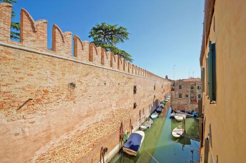 een uitzicht op een gracht naast een bakstenen muur bij DolceVita Apartments N 394 in Venetië