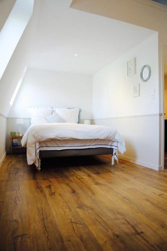 Ce lit se trouve dans un dortoir blanc doté de parquet. dans l'établissement L'archipel, à Lille
