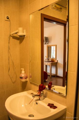 a bathroom with a sink and a mirror at Hotel Pinheiro Manso in Seara