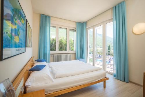 a bedroom with a bed and a large window at Club Hotel Olivi - Tennis Center in Malcesine
