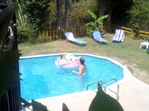 two people in a swimming pool with an inflatable at Georgina Apartments in Mesongi