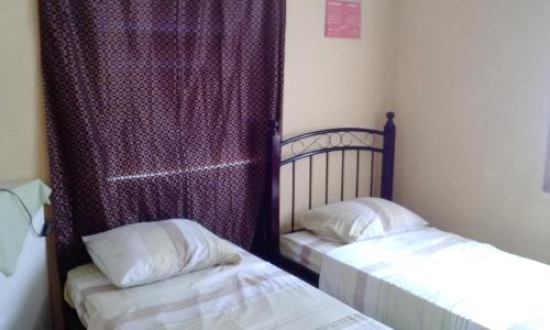 a bedroom with two beds and a window with curtains at Somewhere Special Guesthouse in Gros Islet