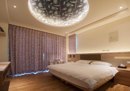 北竿鄉的住宿－馬祖北竿舒漫活海景旅宿 ，一间卧室配有一张大床和一个大型吊灯。