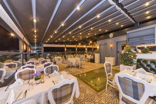 a dining room with white tables and chairs at Alpek Hotel in Istanbul