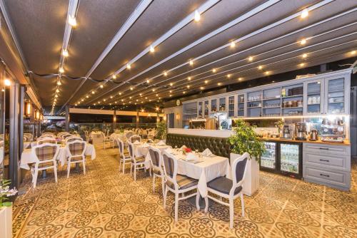 a restaurant with white tables and chairs and a counter at Alpek Hotel in Istanbul
