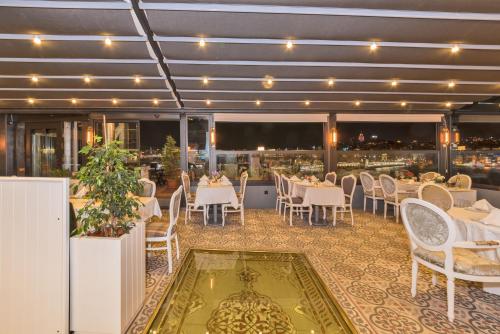 a restaurant with white tables and chairs and a view at Alpek Hotel in Istanbul
