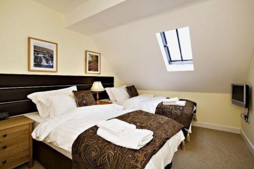 a bedroom with two beds with towels on them at Croft Mill in Hebden Bridge