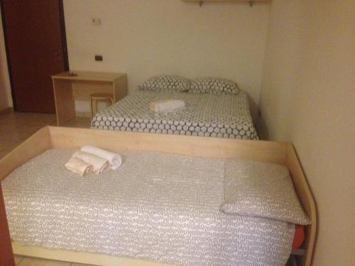 a small bedroom with two beds with towels on them at Mood - Nice One in Pavia