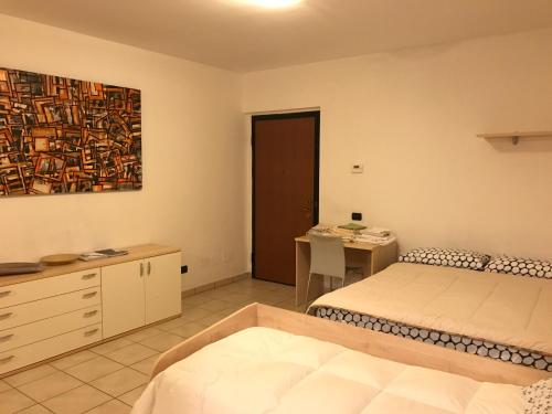 Dormitorio con cama, escritorio y pintura en Mood - Nice One, en Pavia