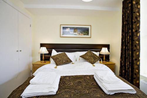 a bedroom with a large bed with white sheets and pillows at Croft Mill in Hebden Bridge