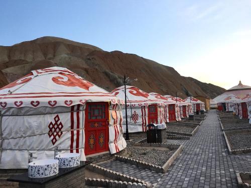 a row of domes are lined up on a mountain at KaoShan Tent Zhangye in Zhangye