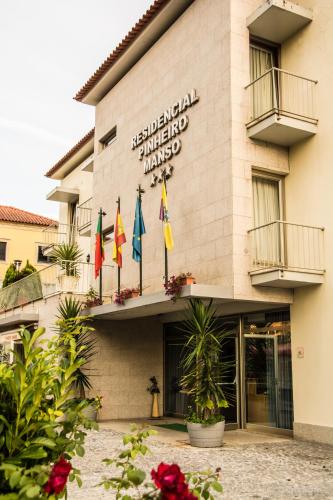 a hotel with flags in front of it at Hotel Pinheiro Manso in Seara