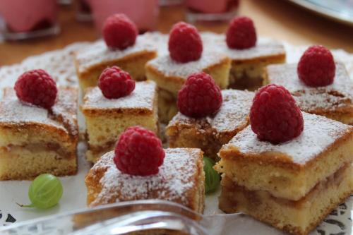 a plate of cake with raspberries on top of it at Dom Przy Plaży in Sarbinowo