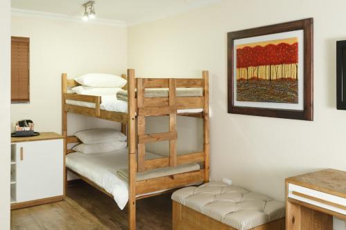 a room with two bunk beds in a room at Loerie Guest Lodge in George