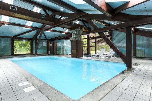 - une grande piscine dans un bâtiment doté de fenêtres dans l'établissement APARTMENT REFUGE DE BELLACHAT - Alpes Travel - Les Houches - Sleeps 4, aux Houches