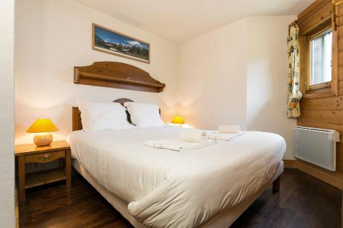 レ・ズッシュにあるAPARTMENT REFUGE DE BELLACHAT - Alpes Travel - Les Houches - Sleeps 4のベッドルーム(大きな白いベッド1台、窓付)