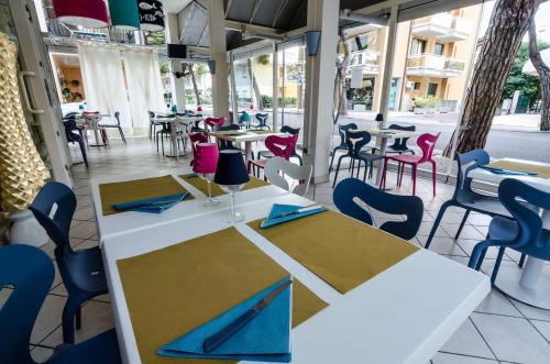 una sala da pranzo con tavoli e sedie e una strada di Hotel Mare Live a Lido di Jesolo