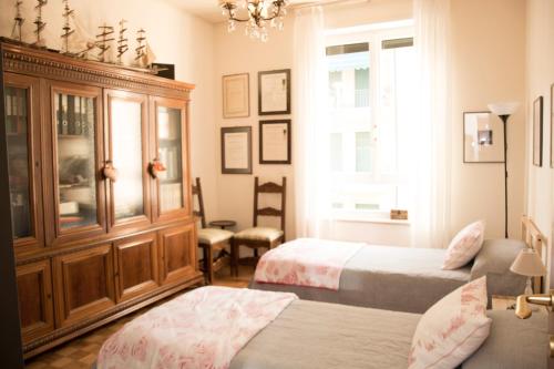 een slaapkamer met 2 bedden en een houten kast bij Casa di Gina in Verona