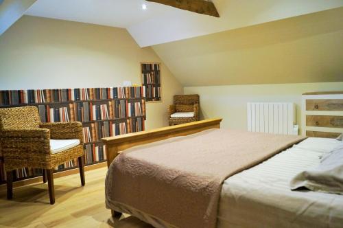 sypialnia z łóżkiem i grupą książek w obiekcie Les Chambres de Saint Hilaire w mieście Saint-Hilaire-Cottes
