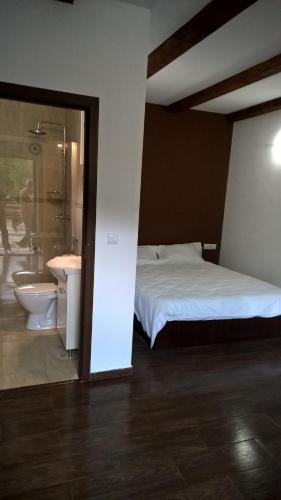 1 dormitorio con cama, bañera y lavamanos en Casutele Andreica, en Vişeu de Sus