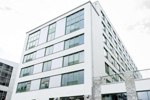 an external view of a white building at Biz Apartment Hammarby Sjöstad in Stockholm