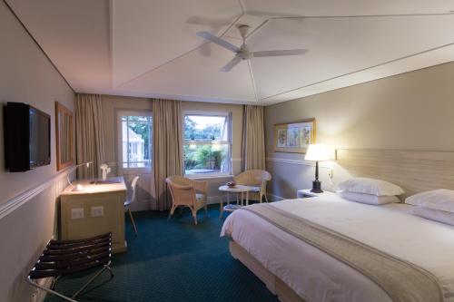 イースト・ロンドンにあるQuarry Lake Innのベッドとテレビが備わるホテルルームです。