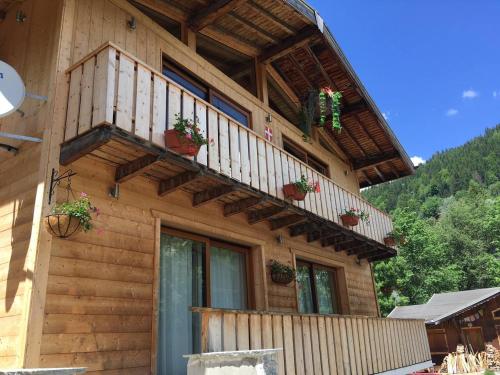a house with a balcony with potted plants on it at Chalet Marmotte 1 in Morzine