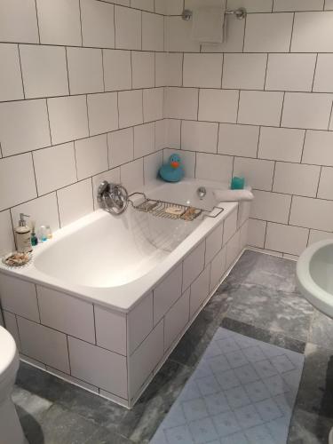 a white bathroom with a tub and a toilet at Roofterrace Apartment in Alkmaar