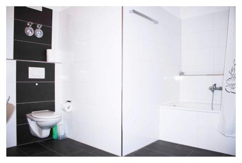 La salle de bains blanche est pourvue d'une douche et de toilettes. dans l'établissement CALIFORNIA Flat - EP Ticket Garantie, à Rust