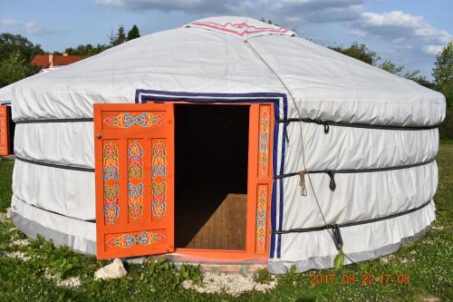 a yurt with an open door in a field at Bagolyvár Fogadó- Újfalusy Márton Vendégház in Zirc