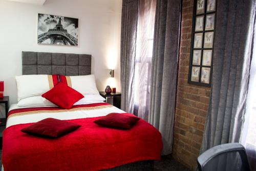 a bedroom with a bed with a red blanket at Trivelles Regency, Nottingham in Nottingham