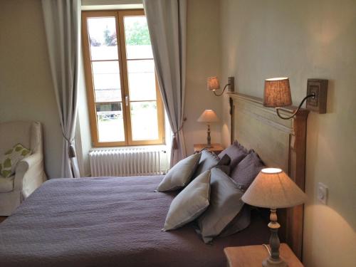 - une chambre avec un lit doté d'oreillers et d'une fenêtre dans l'établissement Le Grand Arbre, à Bayeux