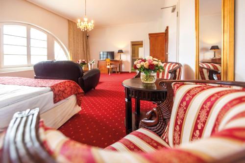 a hotel room with a bed and a table and chairs at Hotel Prinzenpalais Bad Doberan in Bad Doberan