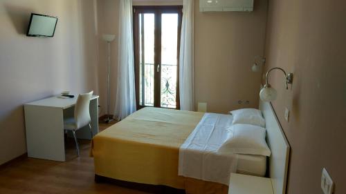 a bedroom with a bed and a desk and a window at La marina in San Benedetto del Tronto