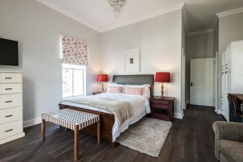 a bedroom with a bed and a desk and a tv at Waterstone Lodge in Somerset West