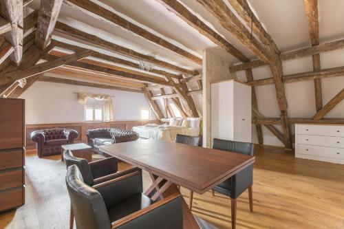 a dining room with a wooden table and chairs at Wellness Hotel Republika 24 Apartments in Plzeň