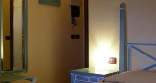 a bedroom with a bed and a mirror and a lamp at Locanda dell'Oca Bianca in Como