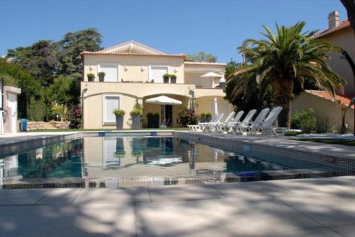 uma casa com uma piscina com cadeiras em frente em Sainte Maxime Studio 2 em Sainte-Maxime