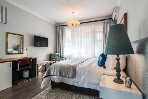 a bedroom with a bed with a green lamp and a desk at Waterstone Lodge in Somerset West