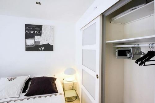 Habitación pequeña con cama y ventana en Le Minerve, en Cannes