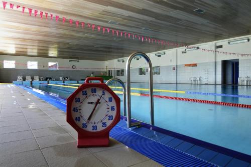 a clock sitting next to a swimming pool at Hotel Srní in Srní