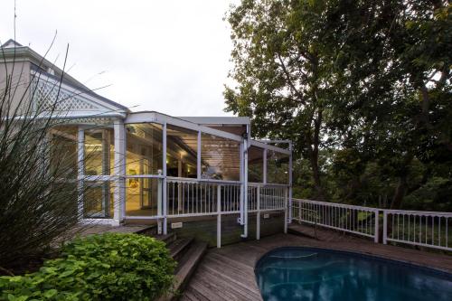 a glass house with a pool on a deck at Quarry Lake Inn in East London