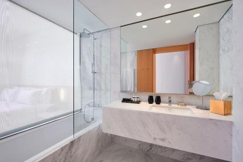 a bathroom with a sink and a shower and a mirror at Melia Palma Bay in Palma de Mallorca