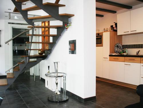 a kitchen with a spiral staircase and a table at Ferienwohnung Tannenweg in Baden-Baden