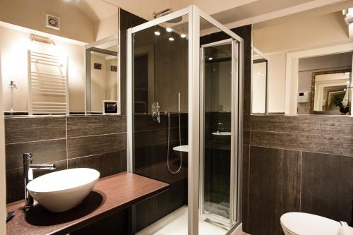 a bathroom with a sink and a glass shower at Adalesia Hotel & Coffee in Turin