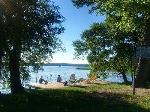 a group of people sitting on a dock by the water at Ferienpark Bad Saarow in Bad Saarow