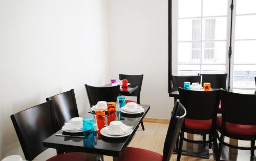 une salle à manger avec des tables noires et des chaises noires dans l'établissement Royal Wagram, à Paris