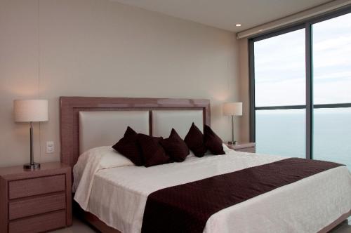 a bedroom with a large bed and a large window at Apartamentos Morros City Cartagena in Cartagena de Indias