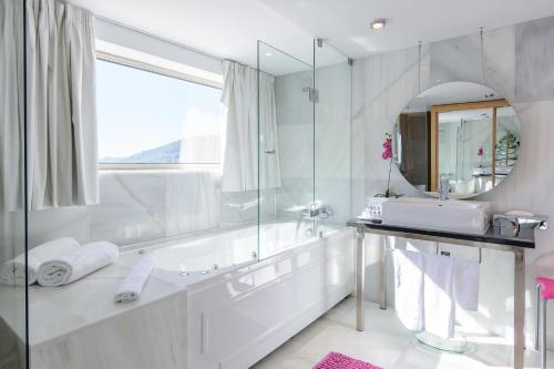 a bathroom with a tub and a sink and a mirror at LAM Hotel dos Carqueijais in Covilhã