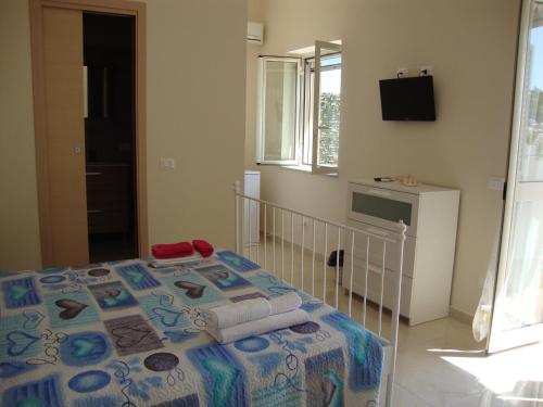 una camera con un letto e una televisione di La Scogliera Turca a Realmonte